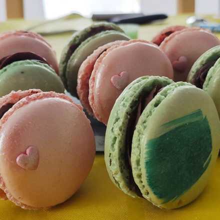 Macarons roses décorés d'un petit cœur et macarons verts