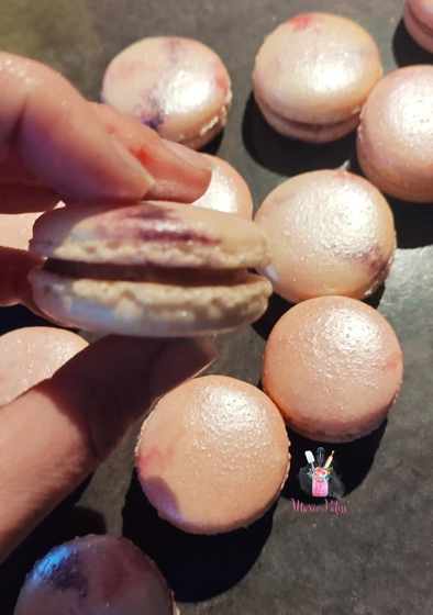 Macarons roses nacrés tenus dans la main